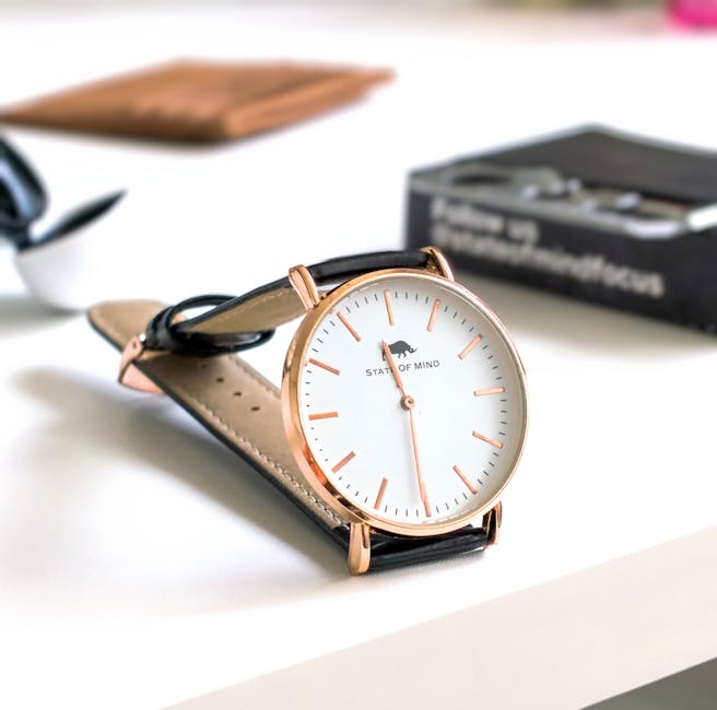 Close-up image of a stylish analog wristwatch with black leather strap and white clock face.