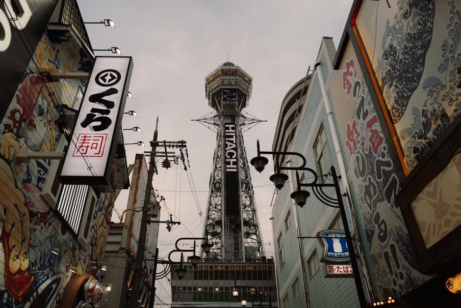 View of Osaka's Tsutenkaku Tower amidst colorful street art and urban architecture, a blend of tradition and modernity.