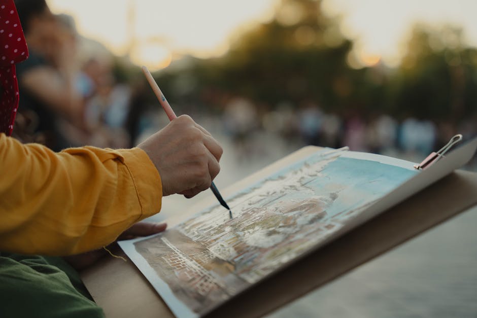 A close-up of an artist painting a cityscape outdoors at dusk, capturing creativity and focus.